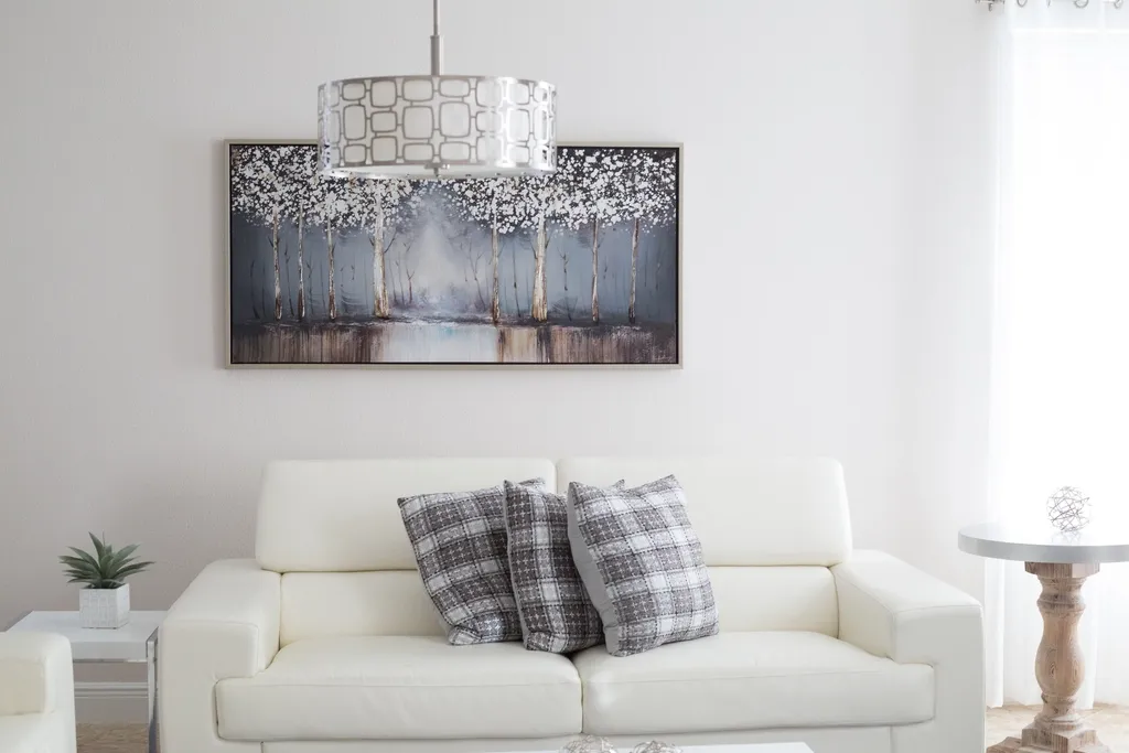 Helles, wohnliches Wohnzimmer mit cremefarbenem Sofa und warmer Lampe